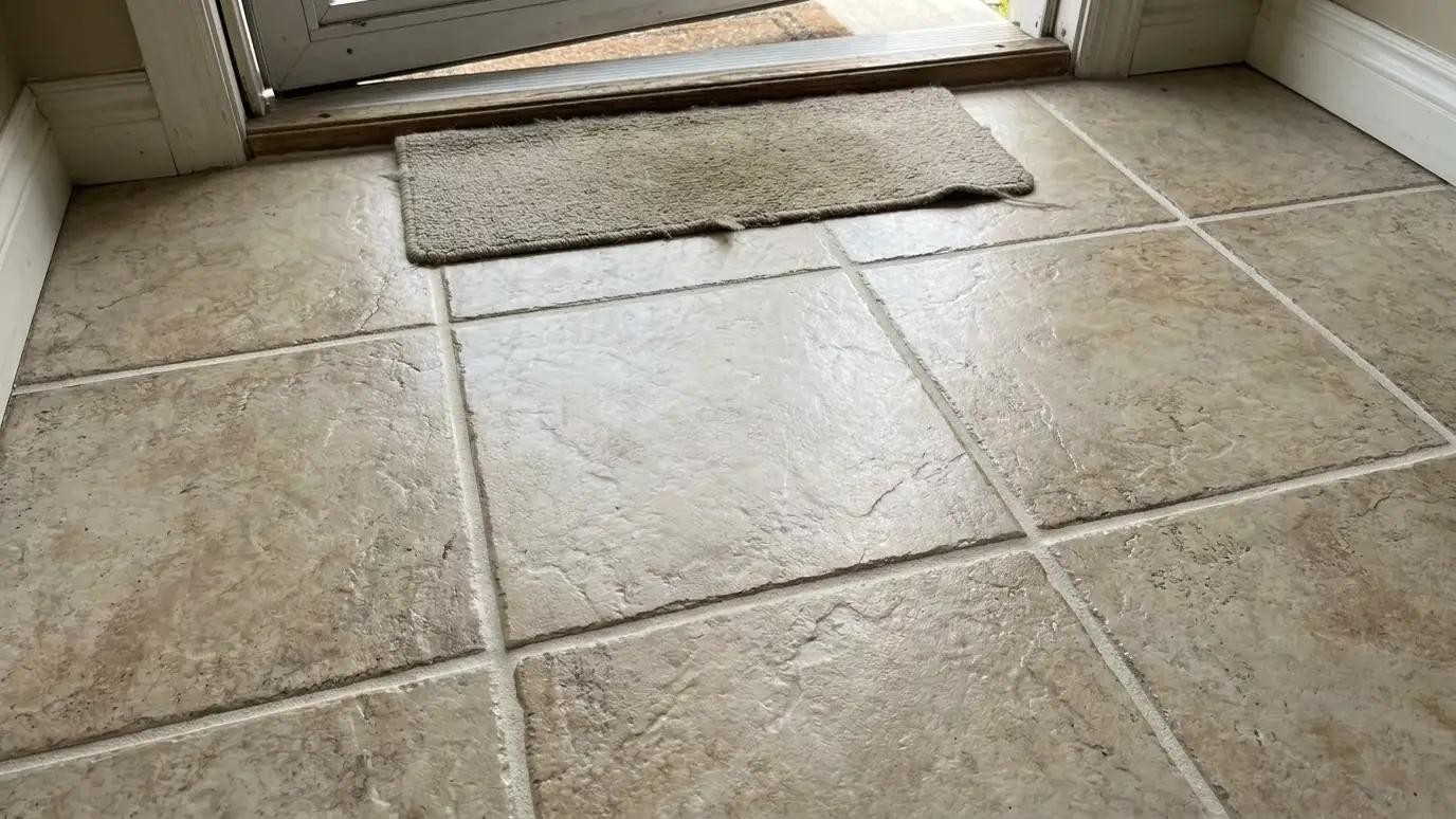 After: a home entry floor with a matching new tile and clean light grout lines